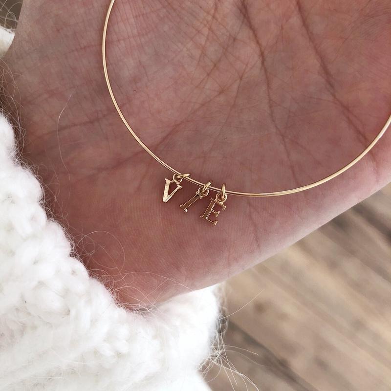 Brazalete «Mey» con la letra «instants-plaisirs» (momentos de placer) 