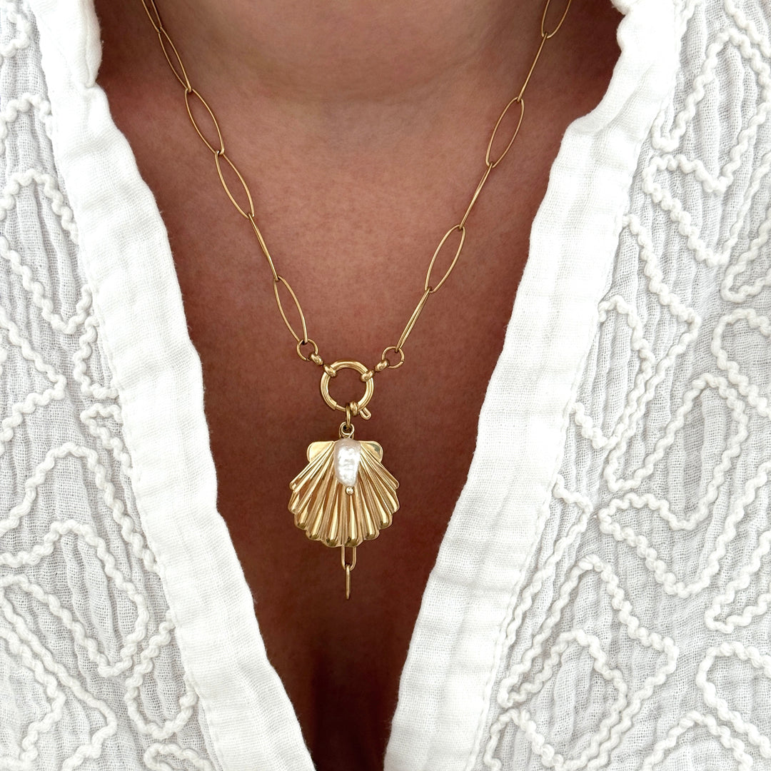 Collier en acier inoxydable  avec chaîne à maillons ovales, pendentif coquillage doré orné d’une perle d’eau douce et d’un anneau central.