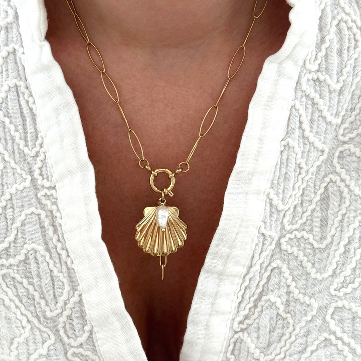 Collier en acier inoxydable  avec chaîne à maillons ovales, pendentif coquillage doré orné d’une perle d’eau douce et d’un anneau central.